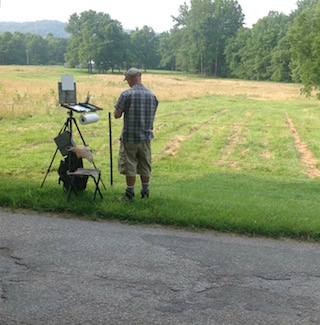 Troy Kilgore painting in field.